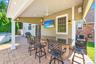 Covered outdoor patio featuring recessed lighting, a ceiling fan, and a built-in bar with a dark stone countertop