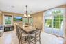 large dining table off kitchen ,Tiled flooring, recessed lighting, and a chandelier illuminate this space featuring multiple windows