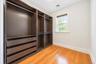 Hardwood flooring, custom built-in closet system with drawers and shelving, double-hung window, crown molding