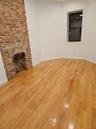 Unfurnished living room with a fireplace, baseboards, and light wood finished floors