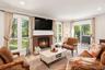 Living Room with Wood Burning Fireplace and Glass Doors to Patio