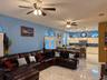Large living room with view to kitchen and access to backyard through French doors