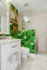 White vanity with louvered cabinet doors, stone countertop, and brass-finish faucet