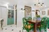 White tile flooring with black diamond inlays, built-in storage with distressed teal doors, and a decorative chandelier with green shades
