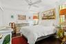 Dark wood-finish flooring, ceiling fan, and white walls