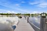 Wood-finish dock extending over water, featuring rope railings, and a decorative dock light