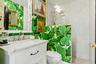 White vanity with a marble countertop, undermount sink, and brass-finish faucet