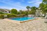 Resort-style rectangular pool with blue tile accents, surrounded by a paver deck