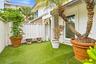 Private outdoor space featuring artificial turf, a white privacy fence, a decorative stone bench, and a large window