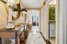 Hallway featuring textured wall covering, decorative arched doorway, and black and white tile flooring