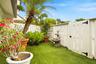 Private outdoor area featuring artificial turf, white picket fencing, and mature palm tree