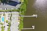Waterfront property featuring an extensive dock, boat slip, and surrounding lush greenery