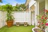 Private outdoor space featuring artificial turf, a white privacy fence, and a stone bench