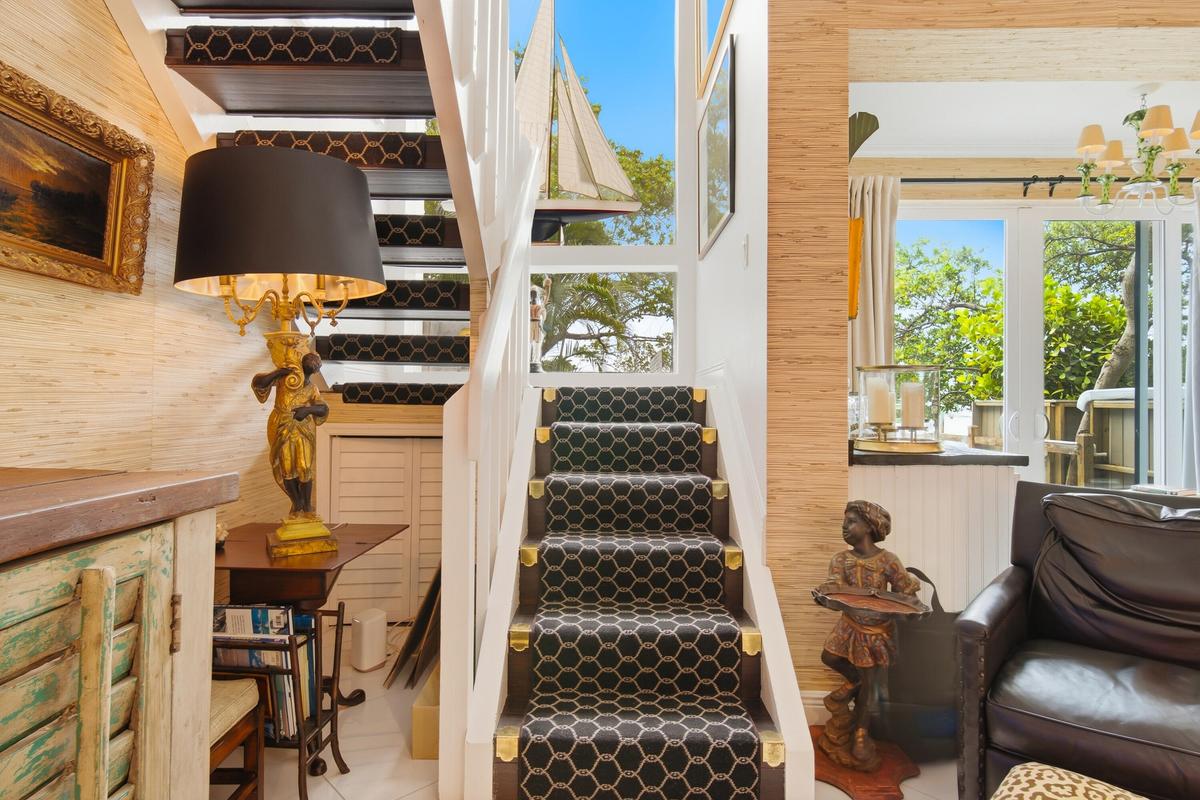 Staircase featuring patterned runner, white risers, and wood treads