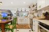 Kitchen featuring white cabinetry, integrated farmhouse sink, stainless steel appliances, and contrasting floor tiles
