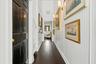 Dark wood-finish flooring with white beadboard wainscoting and wall sconces
