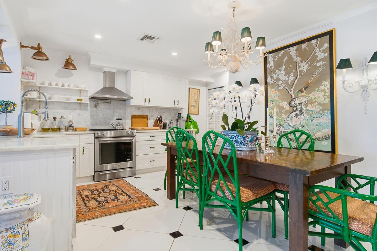 White cabinetry, stainless steel appliances, marble backsplash, marble countertops, and black and white floor tiling