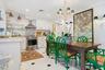 White cabinetry, stainless steel appliances, marble backsplash, marble countertops, and black and white floor tiling