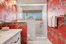 Vanity with a marble countertop, custom cabinetry, and brass hardware