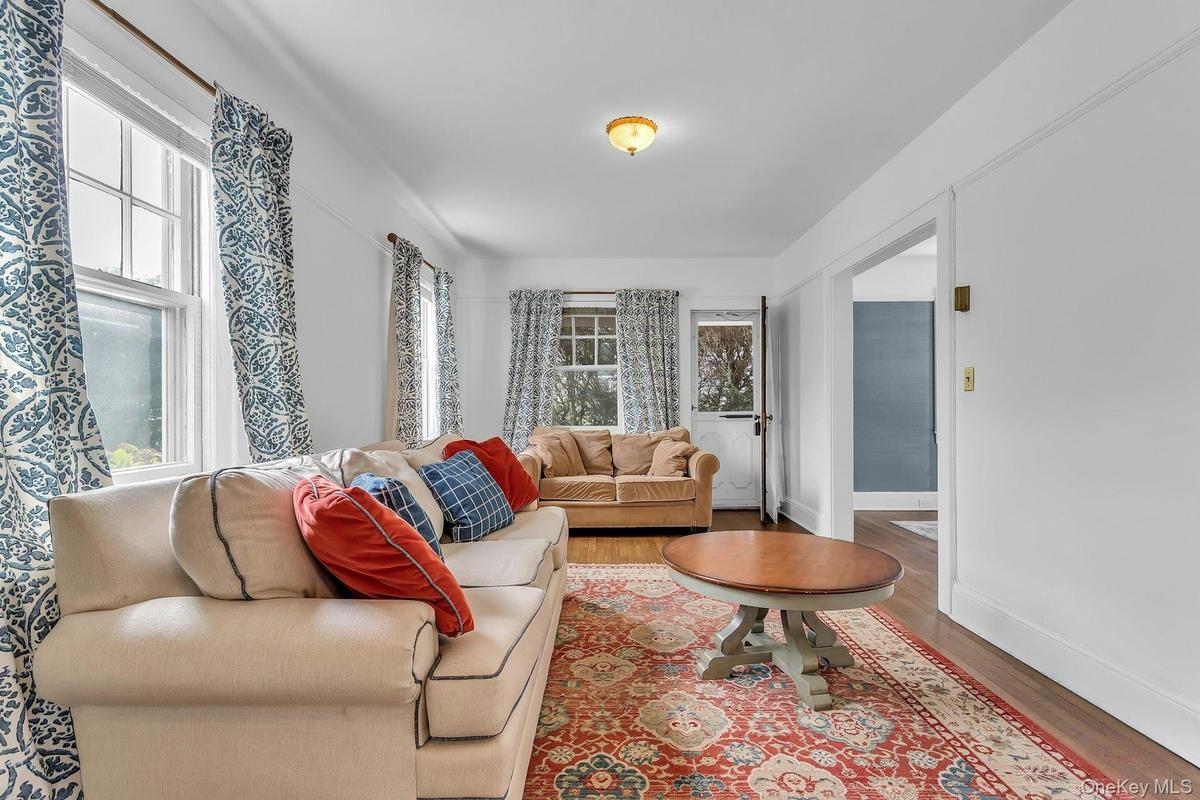 Hardwood flooring, painted white walls, recessed doorway, and a ceiling-mounted light fixture