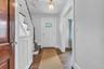 Hardwood flooring, white paneled door with glass inserts, staircase with white risers and wood treads, built-in radiator cover, and hanging light fixt