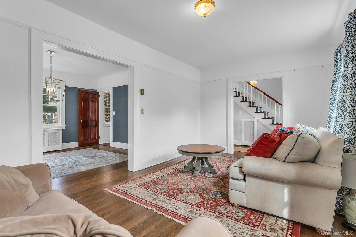 Hardwood flooring throughout, with a traditional staircase and white risers