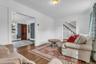 Hardwood flooring throughout, with a traditional staircase and white risers