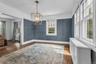 Hardwood flooring, painted accent walls, recessed archway, two pane windows, and a geometric chandelier