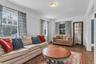 Hardwood flooring, multiple windows providing natural light, white wall finishes, and a classic ceiling fixture