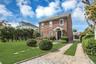Brick exterior featuring a gabled roof and white window trim, long driveway and det garage