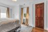 Hardwood flooring, built-in white cabinetry, custom window treatments, and a paneled wood door with decorative hardware