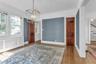 Hardwood flooring, painted walls, white trim, paneled doors, and a decorative ceiling light fixture