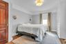 Hardwood flooring, crown molding, built-in cabinetry, two wall sconces, and a ceiling-mounted light fixture