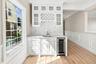 Built-in beverage station featuring white cabinetry, a wine rack, and a beverage cooler.