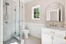 First Floor full bath - glass-enclosed shower with pebble-tile flooring and chrome fixtures