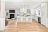 Spacious kitchen with white shaker cabinetry, stainless steel appliances, and a central island with pendant lighting.VIRTUAL STAGING