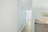 Hallway to 2 bedrooms, 1 full bathroom and additional door to back patio and pool area.