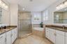 The primary bathroom features dual vanities, quartz finishes and a spacious layout.