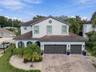 A spacious paver driveway leads to the three car garage
