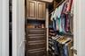 One of two primary suite closets, fitted with custom cabinetry and organizers.