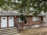 View of front of home with a shingled roof and brick siding