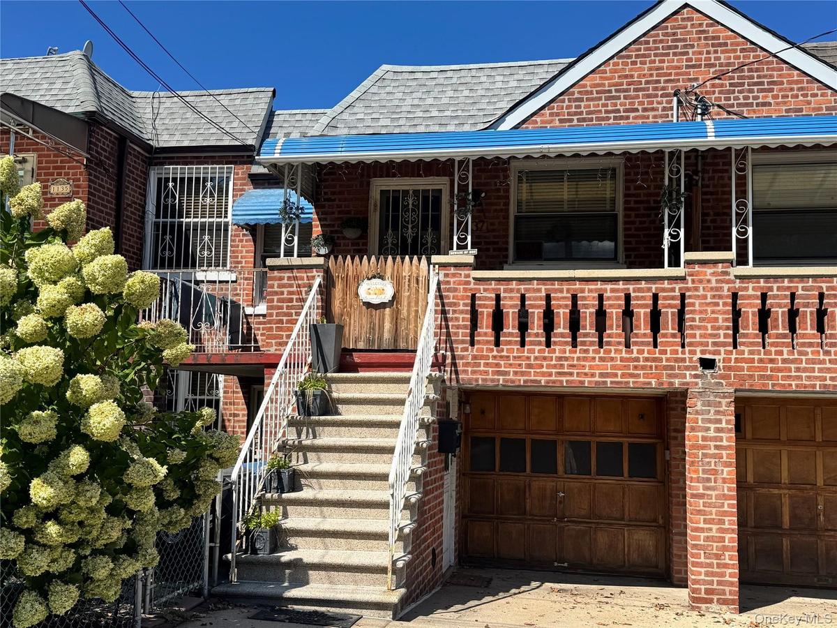 Brick facade with a prominent stone staircase and metal railings