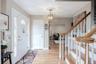 Entryway featuring wood-finish flooring, a white paneled entry door with sidelights, a decorative ceiling medallion with an attached light fixture, an