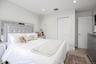 Recessed lighting, white bi-fold closet doors, white paneled door, and neutral-toned carpeting