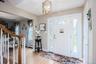 Foyer featuring a paneled entry door with an arched transom, sidelights with decorative glass, and wood-finish flooring