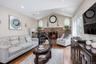 Vaulted ceiling living area featuring hardwood flooring, a brick fireplace, French doors, and recessed lighting