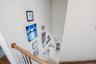 Two-story wall, wood-finish handrail, white painted risers, and wood-finish flooring