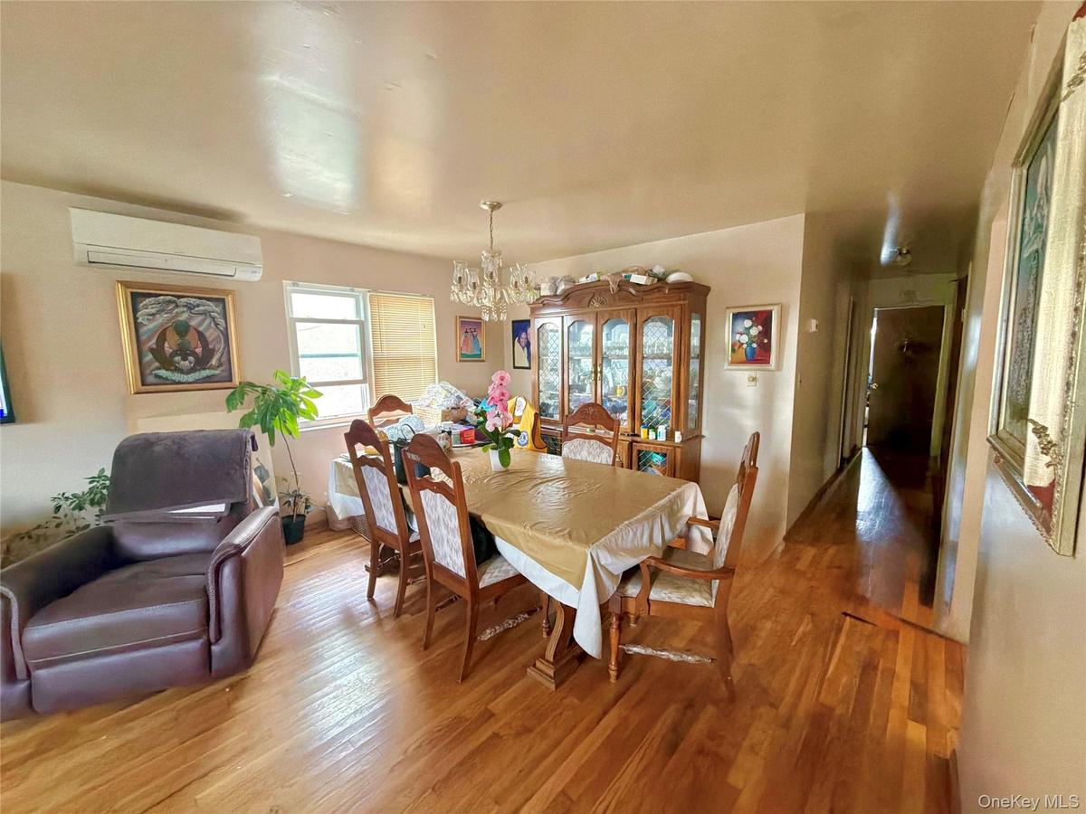 Hardwood flooring throughout, with a crystal chandelier and prominent window