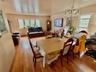 Hardwood flooring throughout, multiple windows, and a clear glass chandelier