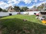 Expansive grassy yard with white privacy fencing